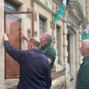 Members of the Men's Shed installing new signage