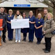 Chloe Burridge presenting her cheque to Seaton & District Hospital League of Friends trustees and Seaton Hospice at Home nurses